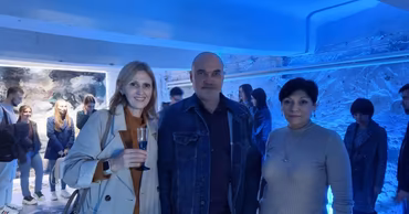Lilia Dragneva standing with two other people at an art exhibition.