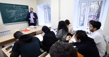 A teacher lecturing to a diverse group of international students in a classroom in Moldova.