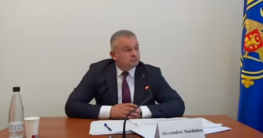 Alexandru Machidon sitting at a table with a nameplate in front of him.