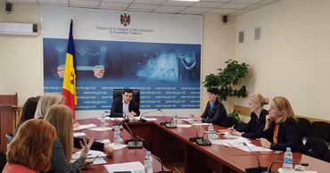 A group of officials sitting at a conference table in a Moldovan government office.