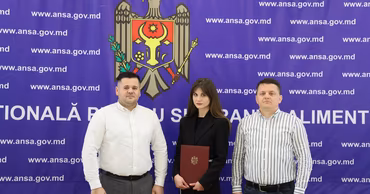 Three people standing in front of an ANSA branded backdrop in Moldova.