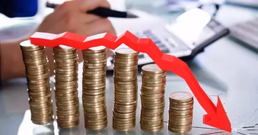 Stacks of coins with a red downward arrow graph indicating financial loss or economic deficit.