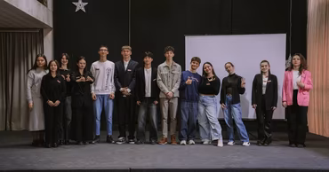A group of young people standing on a stage during an event.