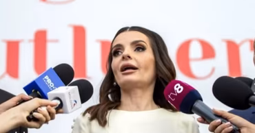Evghenia Gutul speaking to journalists with microphones in front of her.