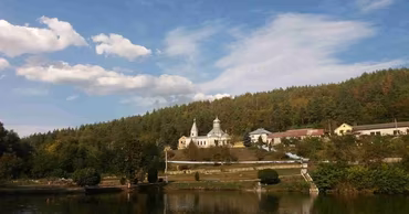 A scenic view of the Dniester river with a church on the bank in Cosauti, Moldova.