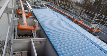 Industrial water treatment facility with pipes and metal structures.