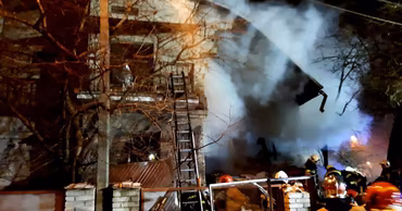 Firefighters working at the scene of a house explosion at night.