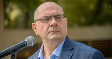 Portrait of Alexandr Petkov speaking into a microphone.