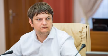 Andrei Spinu sitting at a table during a meeting.