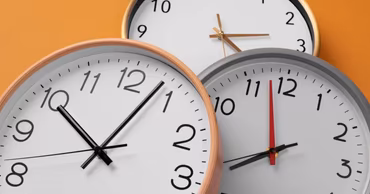 Three analog wall clocks showing different times against an orange background.